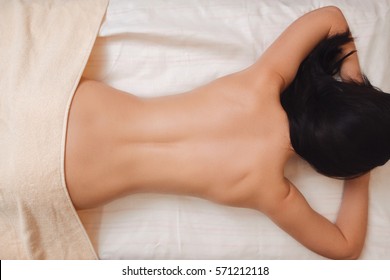 Naked girl seen from behind lying down